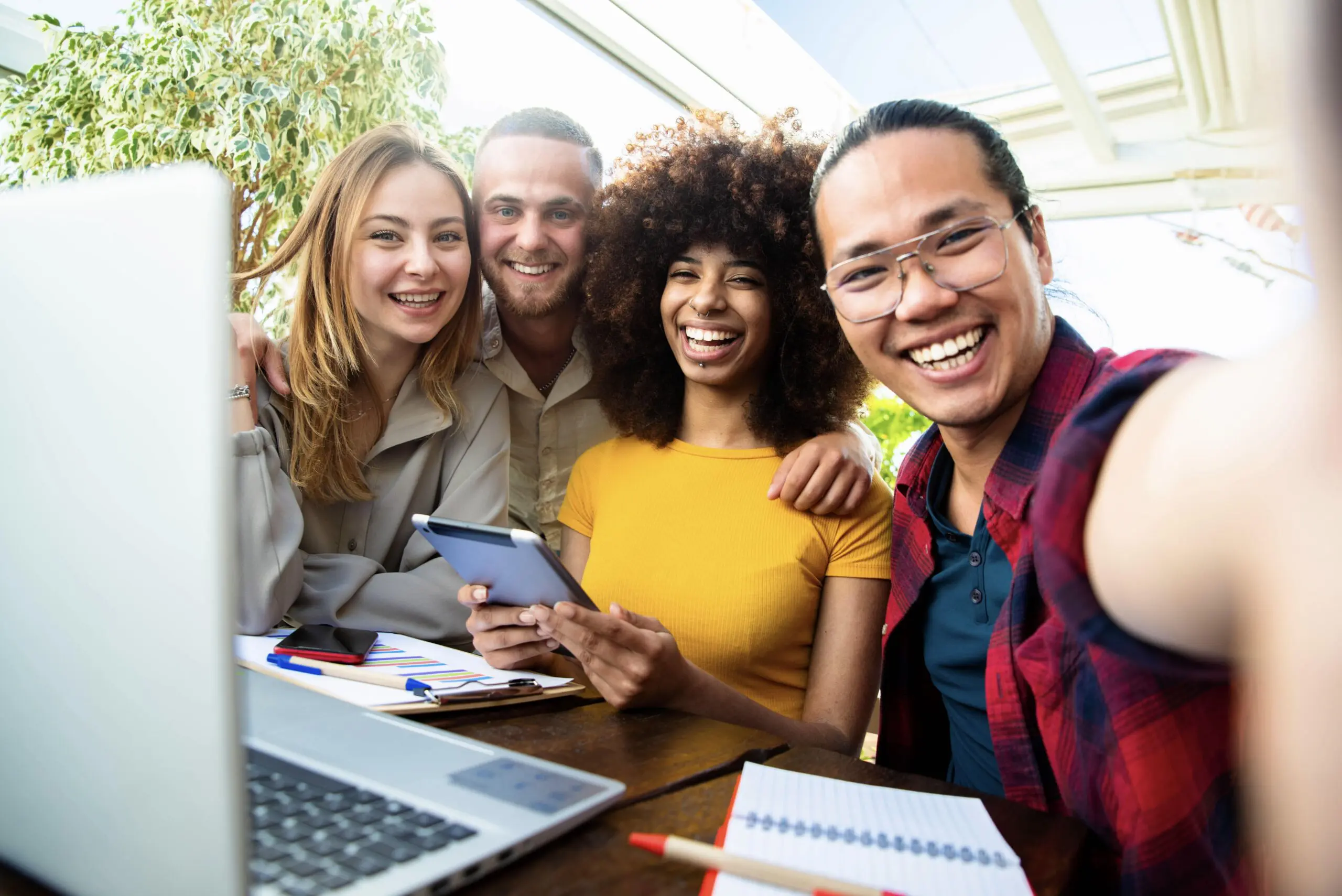 Group of four happy international students smiling at the camera, ready for their academic journey with a French student visa