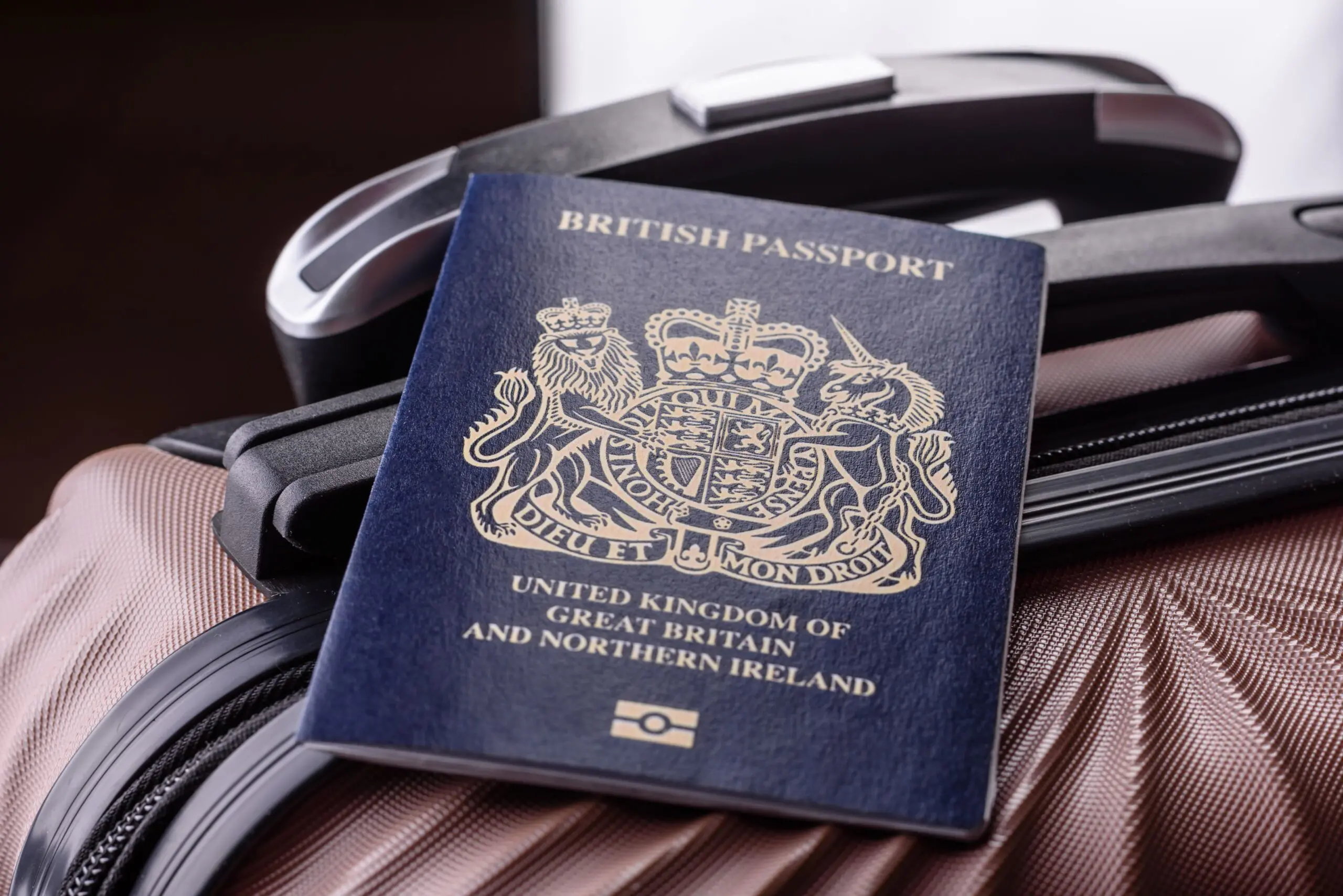 British passport resting on a suitcase, representing dual residency between the UK and France
