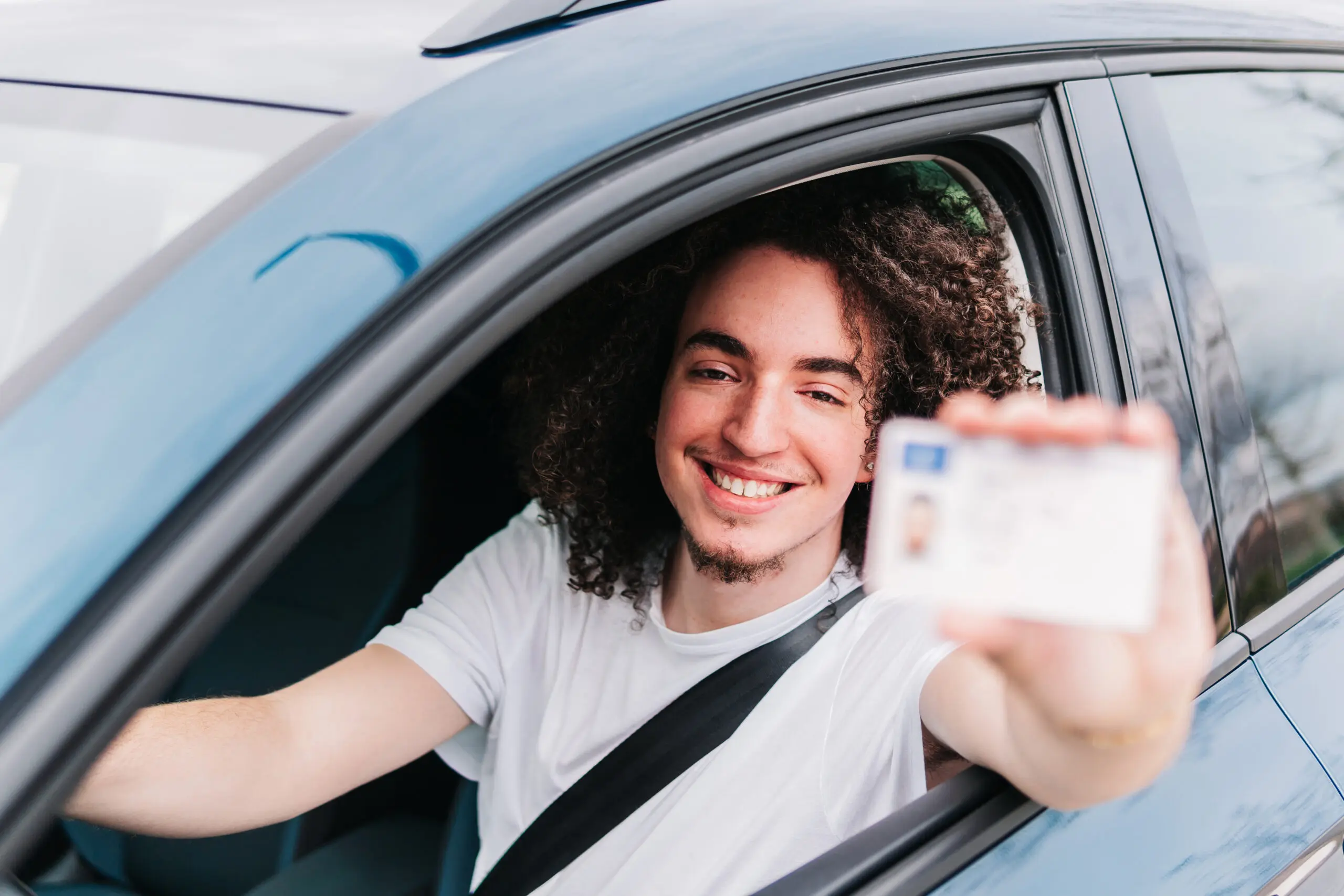 Person holding a driving license alongside French identity documents, representing the foreign license exchange process in France