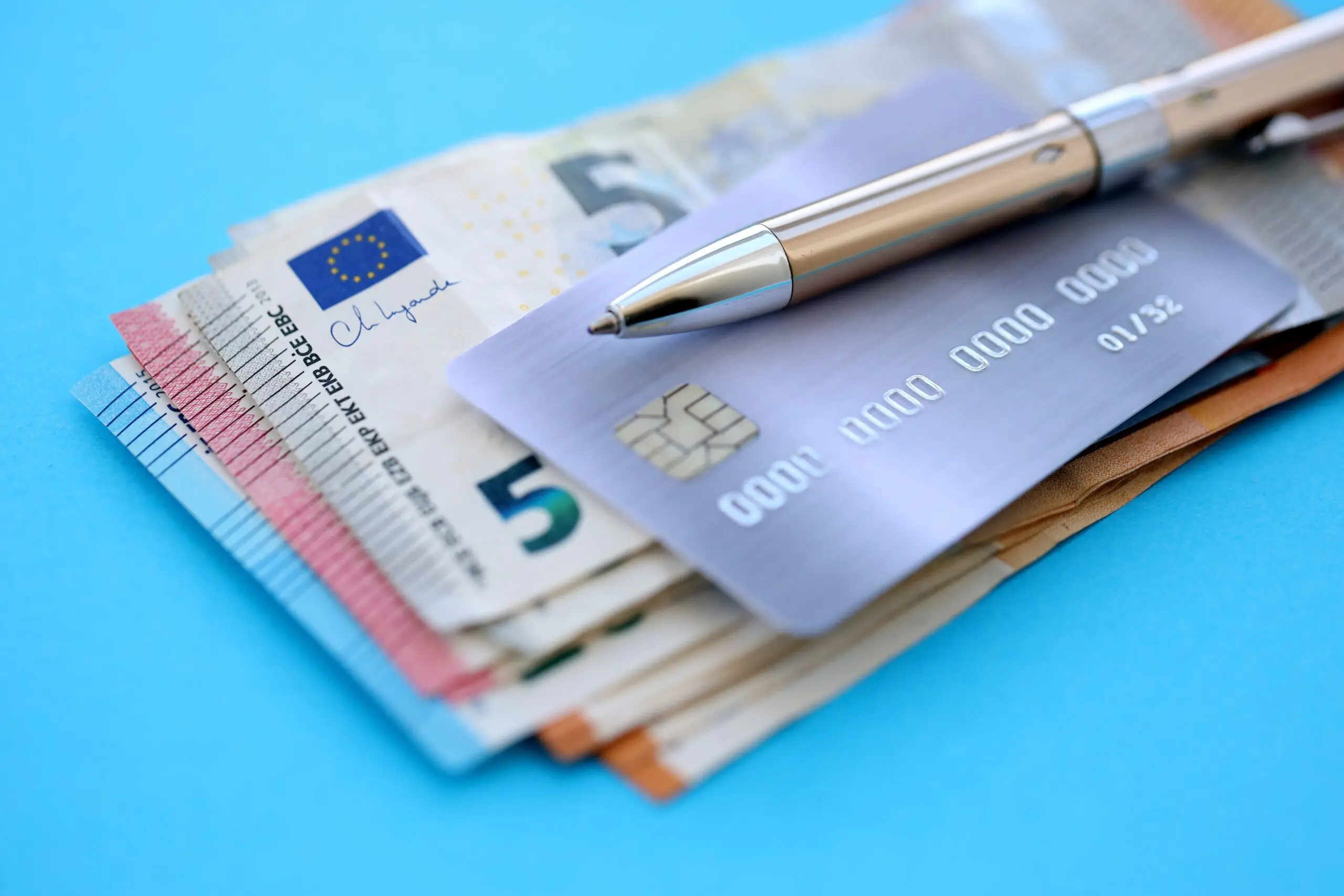 Euro banknotes with a bank card and pen, representing opening a French bank account as a foreigner